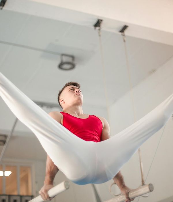 A strong man performing a bodyweight exercise in a minimalist gym.